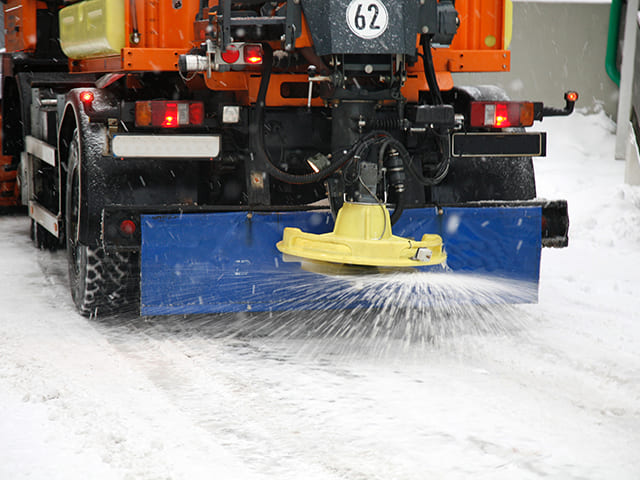 saleuse en action sur une route enneigée